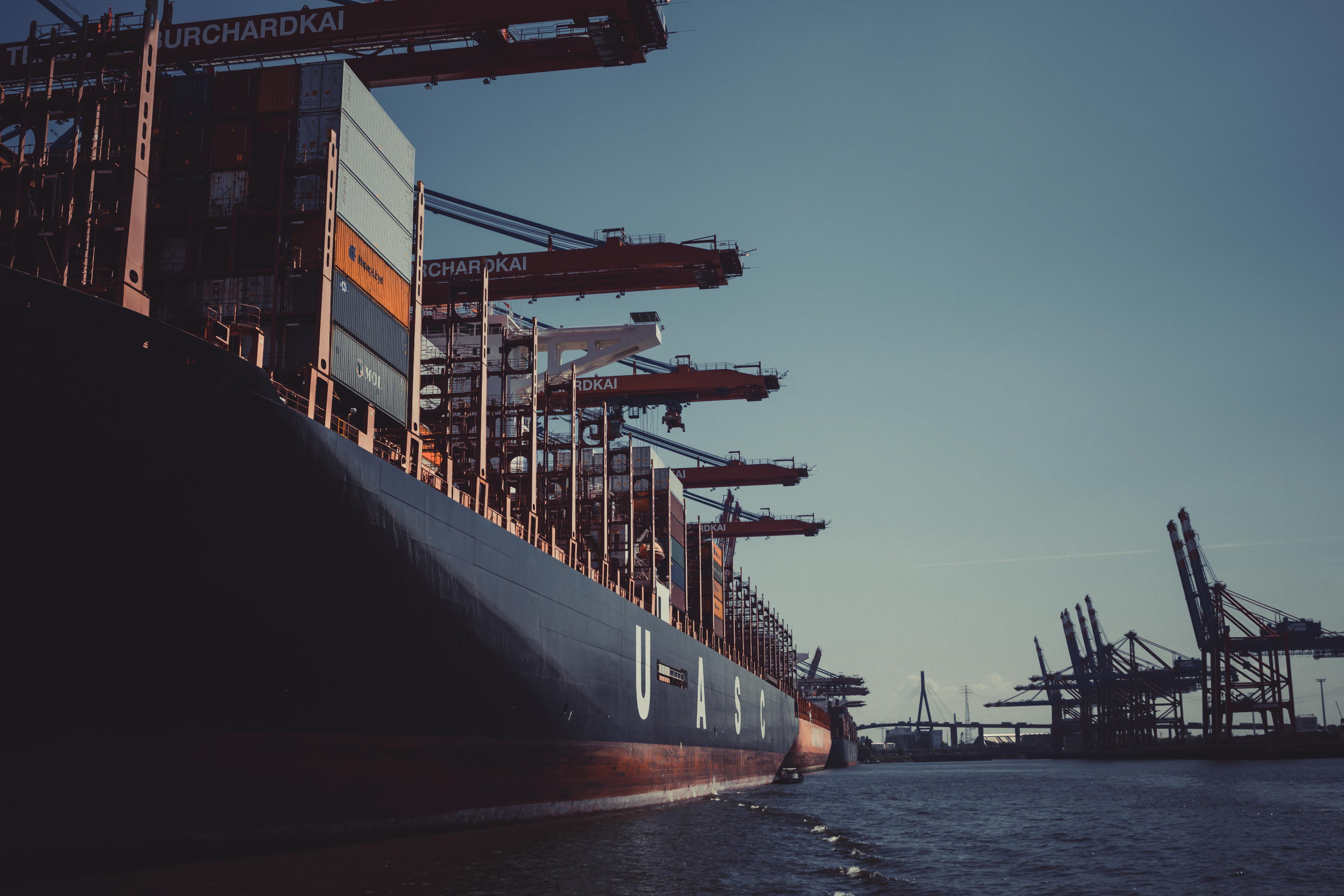 Image of a large cargo ship with cranes in a port